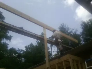 Carpenter setting a ridge beam over a new addition frame — Ice Dam Removal by Roofing Brothers in Eaton Rapids