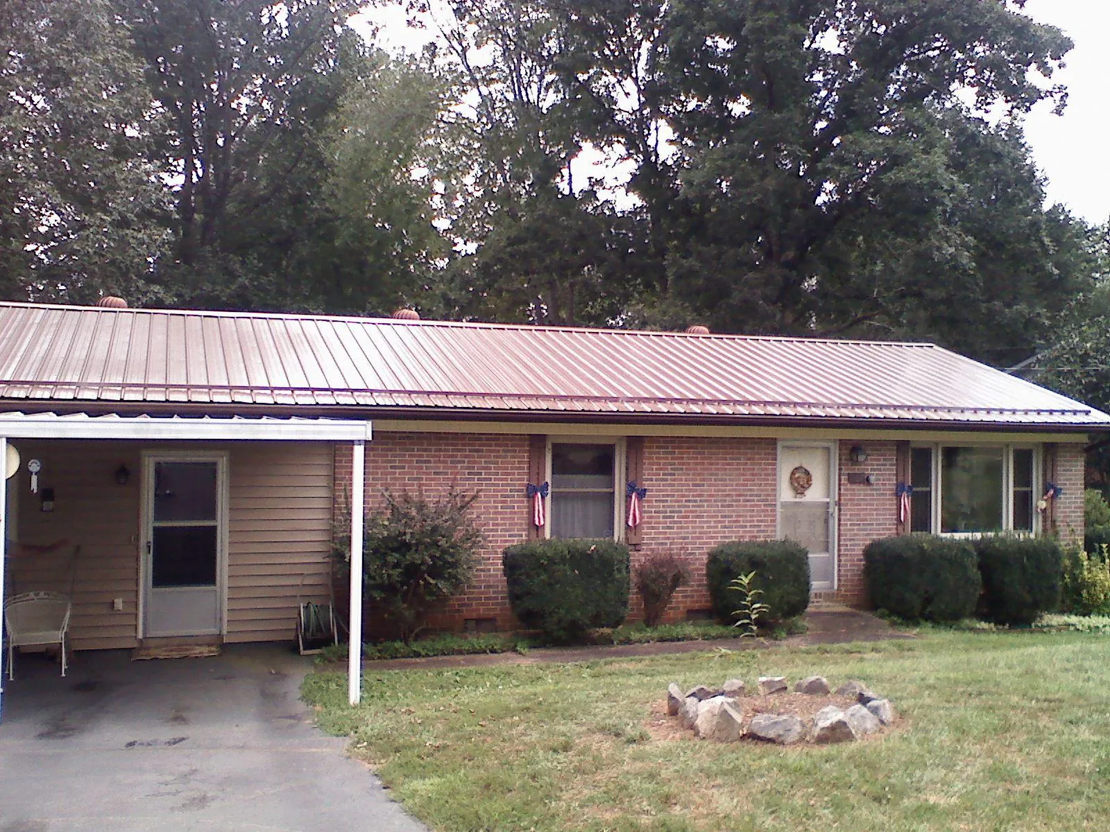 Bronze metal roof and carport on a brick ranch home — Roof Repair work by our crew in Eaton Rapids